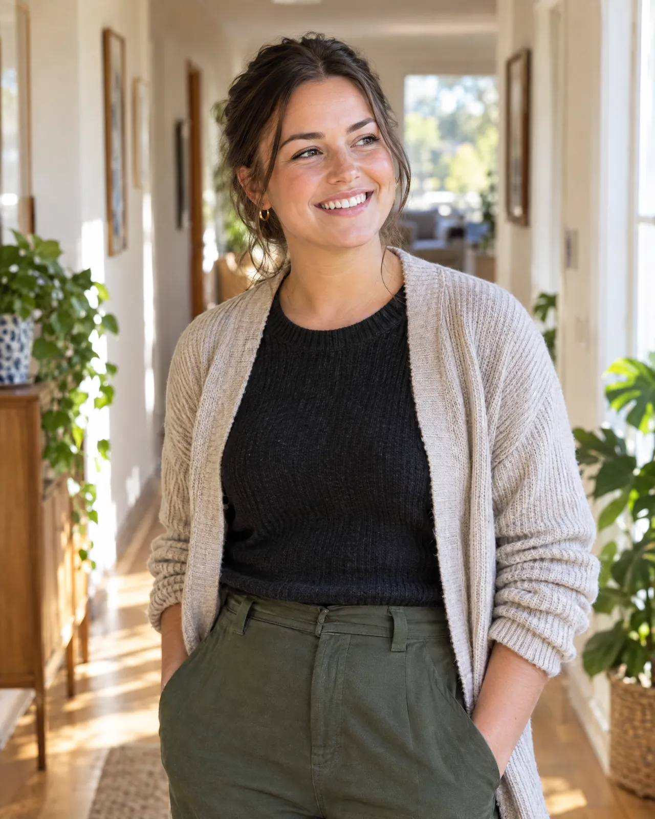 A smiling support worker standing in a sunlit hallway
